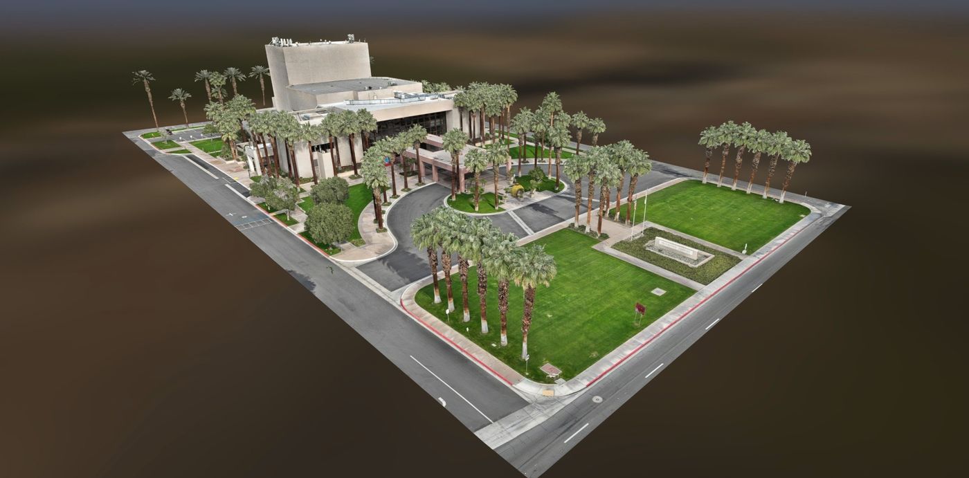 Textured aerial 3D model of a performing arts centre and its grounds — building, parking, roads and palm-lined lawns captured as one dataset.